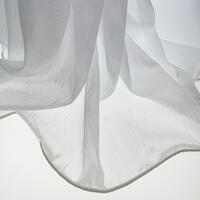 Open vitrage van glansgaren. Hier en daar zitten er wat verdikkingen in het garen voor een speels effect.